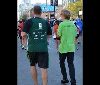 Andrew running side by side a Marathon Runner