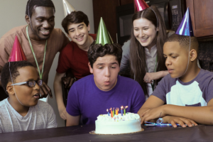 Young man blows out candles at a birthday celebration