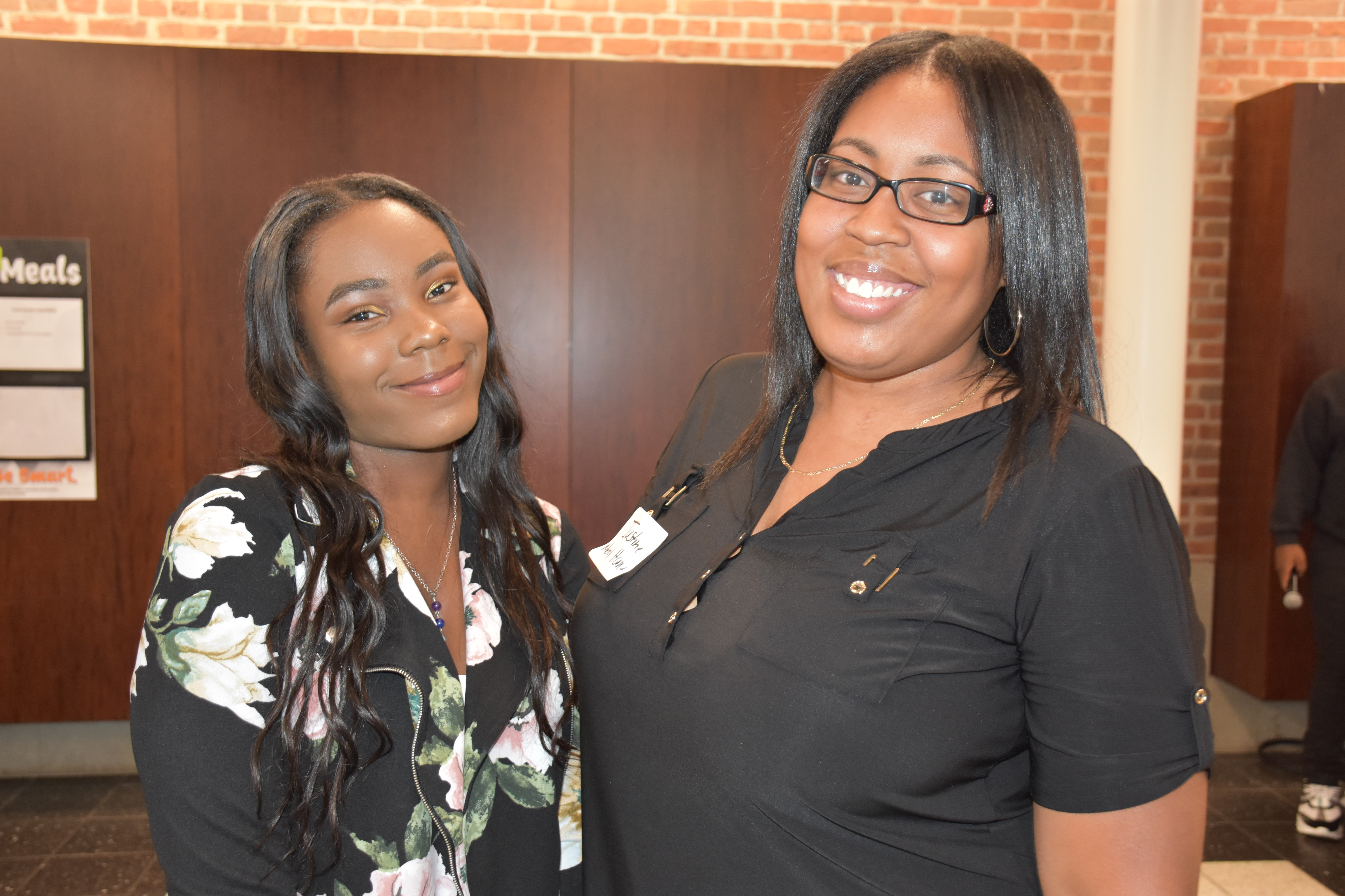 Two young women smiling at employer appreciation dinner