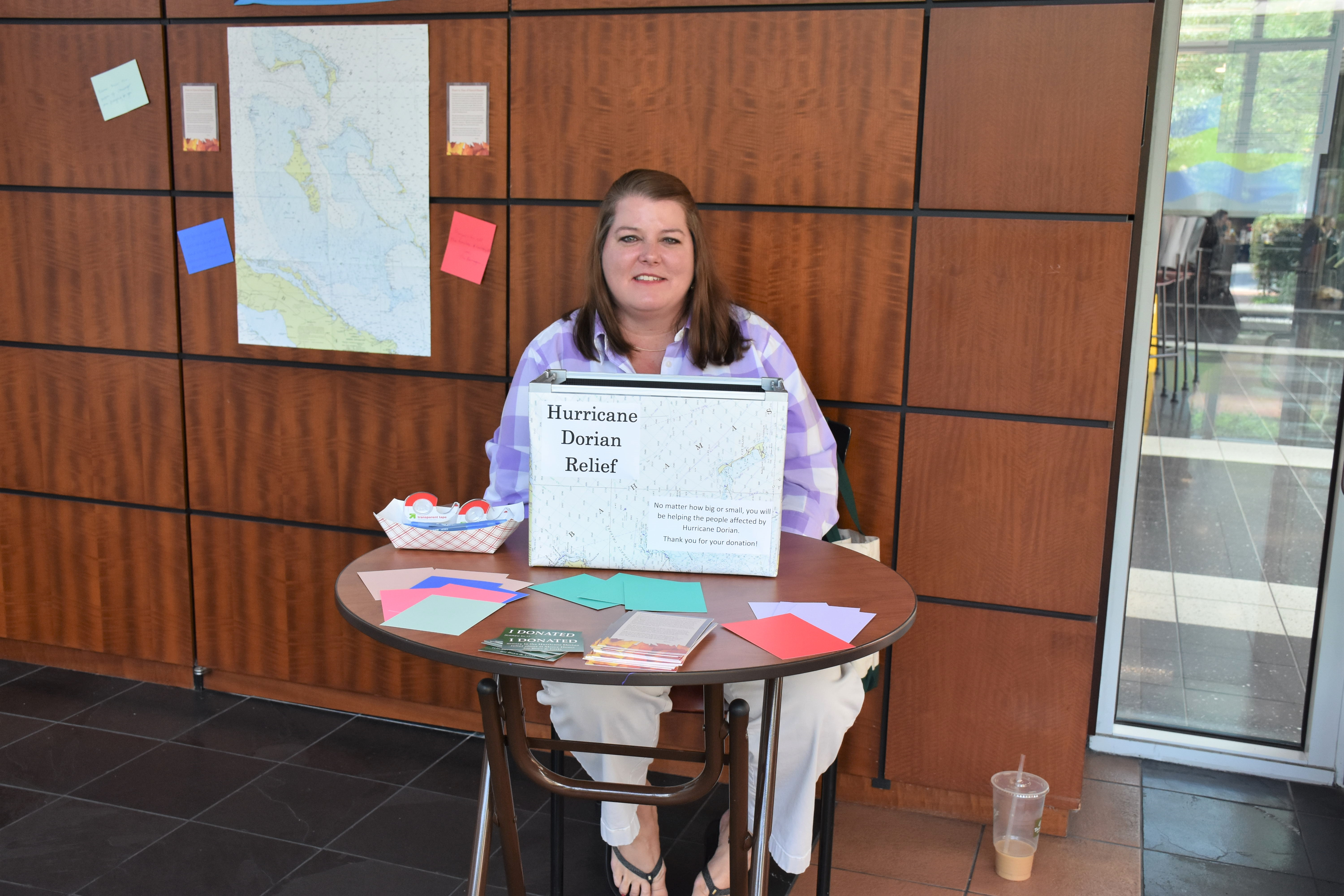 Woman sitting at hurricane relief donation table