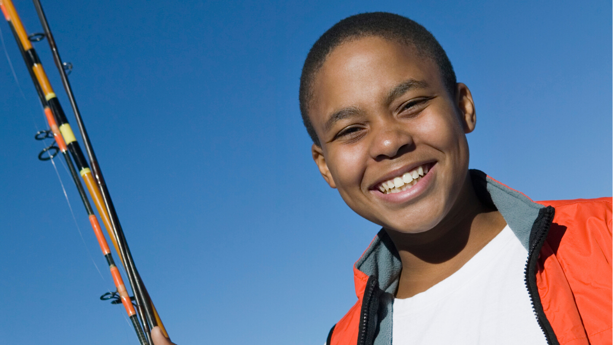 Young smiling boy with fishing rod