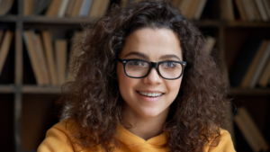 girl sitting in library and smiling