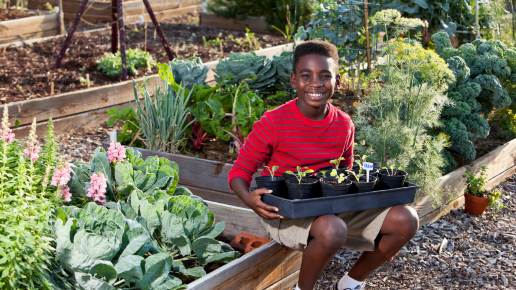 Young boy sitting in garden and smiling