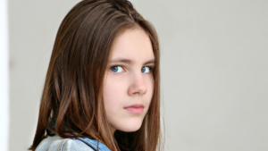Young girl looking at the camera with a frown