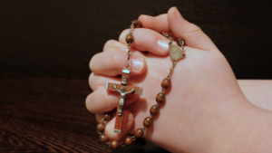 Hands folded in prayer with rosary