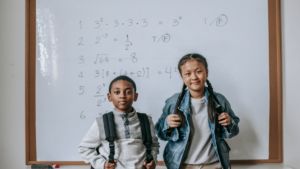 young kids standing in front of a whiteboard
