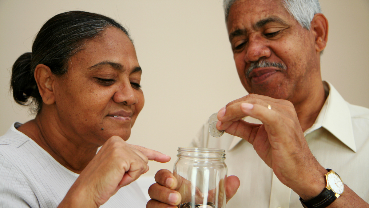 Couple puts coins in a jar