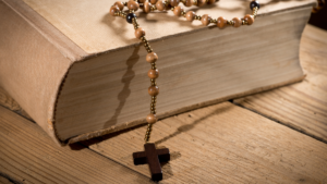 Bible with rosary draped across it