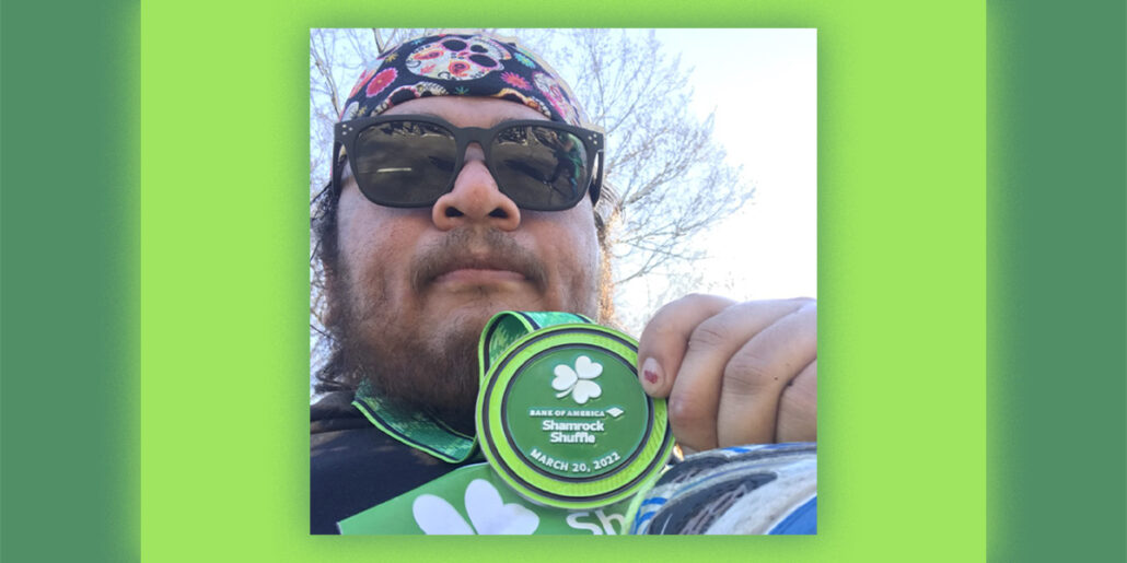 Head chef Alan holds up his medal for running in the 2022 Bank of America Shamrock Shuffle.