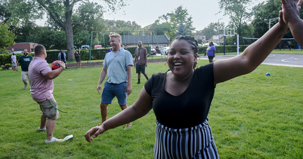 One of our girls reaches for a high-five as she smiles and walks across the Mercy Home lawn.