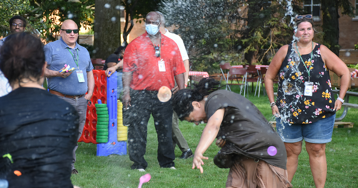A water balloon splashes onto a woman at the Mercy Home annual Field Day.