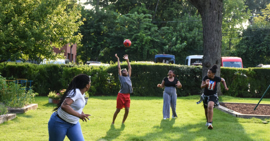 The Mercy Home girls are running around the garden playing with a soccerball.