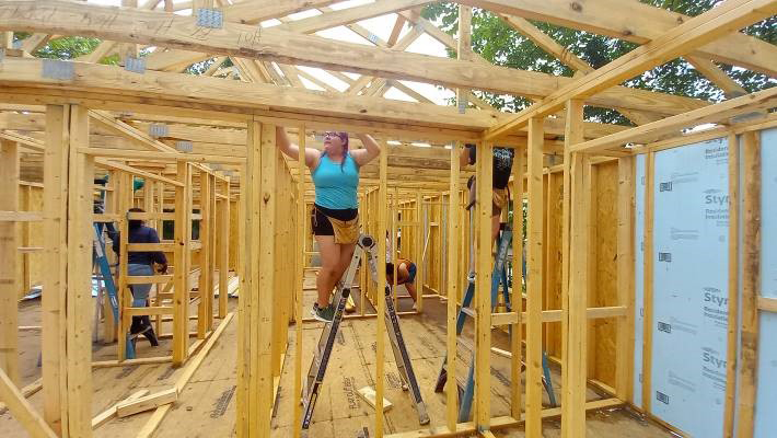 One of our young women building a house.