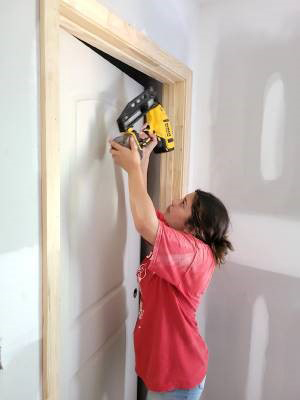 Young woman building a door.
