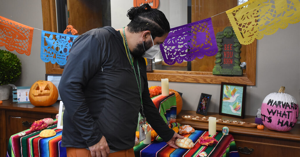 A Mercy Home coworker lays some pan dulce on a decorated ofrenda as he observes DÍa de los Muertos.