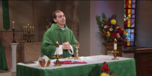 Fr. James Wallace says a prayer as he prepares communion for the Sunday Mass at Mercy Home community.