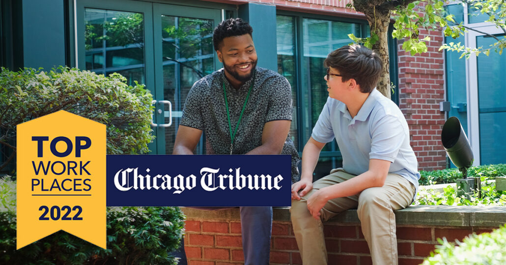 A Mercy Home youth care worker and one of our kids sit next to a fountain. In the foreground, a yellow ribbon reads "Top Work Places 2022". A blue rectangle displays the Chicago Tribune logo in white.