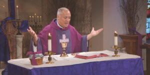 Fr. Jason Malaqve prepares communion as he leads mass for the Third Sunday of Lent.