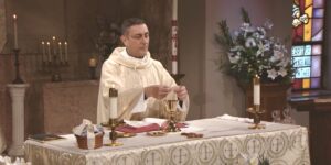 Fr. Carl Morello prepares communion as he leads the Sunday Mass community at Mercy Home on the Fourth Sunday of Easter.