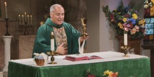 Fr. Malave lifts the gold chalice to bless this week's communion as he leads the Sunday Mass community at Mercy Home in celebration of the Twelfth Sunday in Ordinary Time.