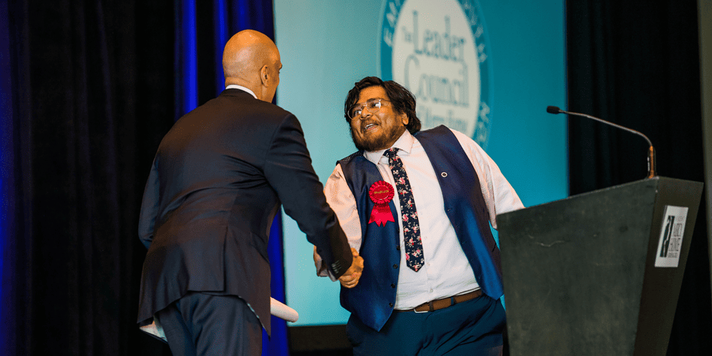 Mercy Home chef and alum Alan shakes hands with Jim Williams, co-anchor at CBS Chicago and host of the 21st Graduates Luncheon. 