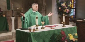 Fr. Morello raises his hands to bless this week's communion as he leads the Sunday Mass community at Mercy Home in celebration of the Thirteenth Sunday in Ordinary Time.