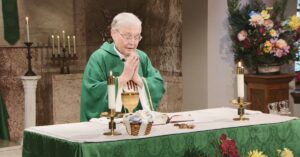 Very Rev. Sakowicz raises his hands to bless this week's communion as he leads the Sunday Mass community at Mercy Home in celebration of the Sixteenth Sunday in Ordinary Time.