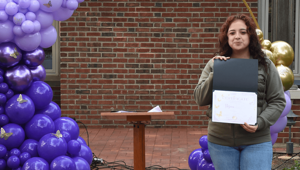 A young woman celebrates her academic award.