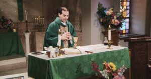 Fr. James Wallace raises his hands to bless this week's communion as he leads the Sunday Mass community at Mercy Home in celebration of the Twentieth Sunday in Ordinary Time.