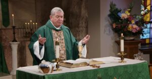 Fr. Scott Donahue raises his hands to bless this week's communion as he leads the Sunday Mass community at Mercy Home in celebration of the Twenty-First Sunday in Ordinary Time.