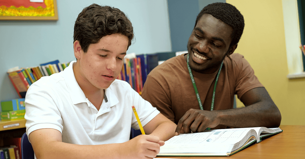 A youth care worker sits down with one of our kids to help them with homework.