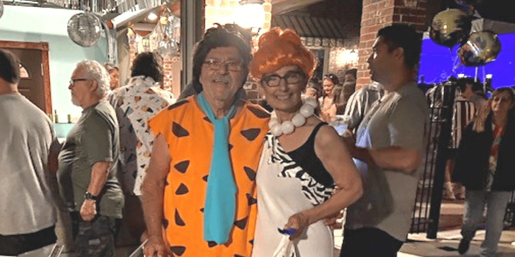 Mario and Karen Licitra dress as Fred and Velma Flintstone as they host the 70s-themed fundraiser.