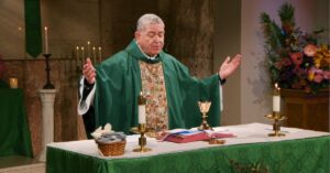 Fr. Scott Donahue raises his hands to bless this week's communion as he leads the Sunday Mass community at Mercy Home in celebration of the Twenty-Eighth Sunday in Ordinary Time.