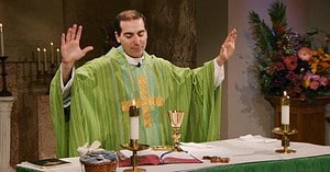 Fr. James Wallace raises his hands to bless this week's communion as he leads the Sunday Mass community at Mercy Home in celebration of the Twenty-Ninth Sunday in Ordinary Time.