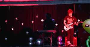 Young man performs a song on his electric guitar.