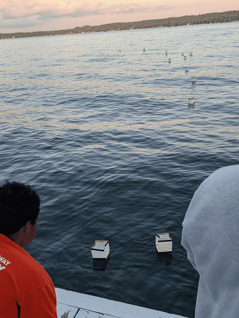 A couple Mercy Home youth set their vision cubes adrift on the lake.