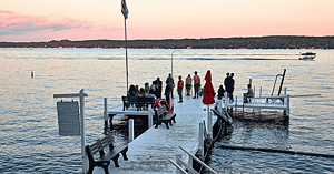 A group of youth and staff gather on the pier at the lake.