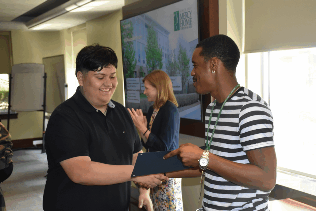 A Mercy Home youth receives an award for his hard work.